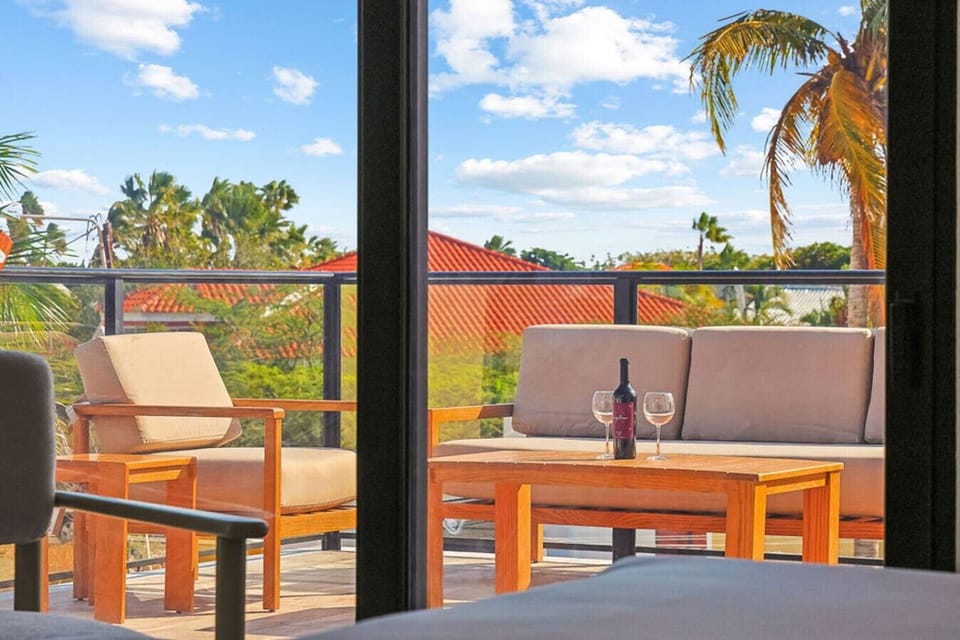 Private Balcony Escape with Cozy Seating, Wine for Two, and Tropical Views—Perfect Spot to Unwind and Enjoy Peaceful Sunset Moments