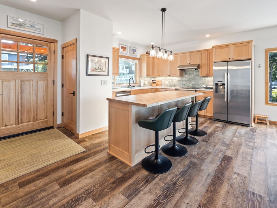 You'll love gathering around this spacious kitchen island with premium appliances, warm wood cabinetry, and stylish bar seating perfect for morning coffee or evening meals.