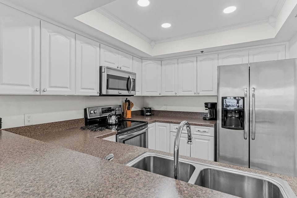Well-equipped kitchen includes stainless steel refrigerator, range, microwave and dishwasher.