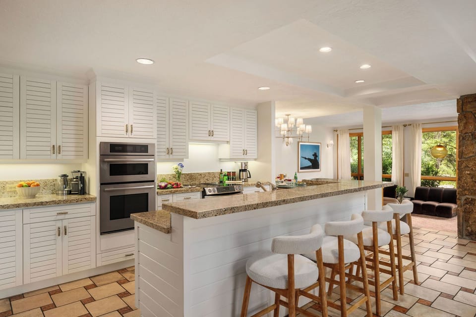 Gather around the spacious island in your bright, beautifully appointed kitchen, where white shaker cabinets and granite countertops create a timeless coastal feel. Large windows invite natural light, making meal prep and conversation effortless.