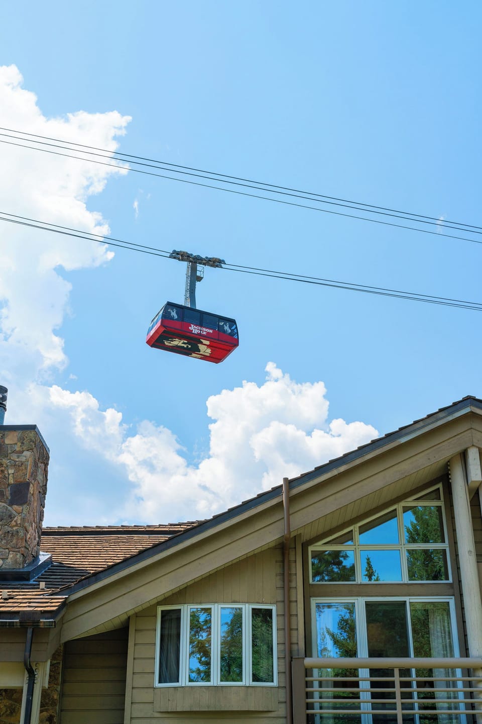 An aerial gondola glides above the property, providing easy access to nearby mountain slopes and recreational areas throughout the seasons.