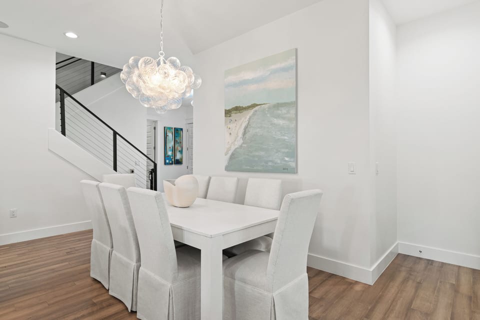 Your elegant dining space features coastal artwork and a stunning chandelier, perfect for memorable meals together.