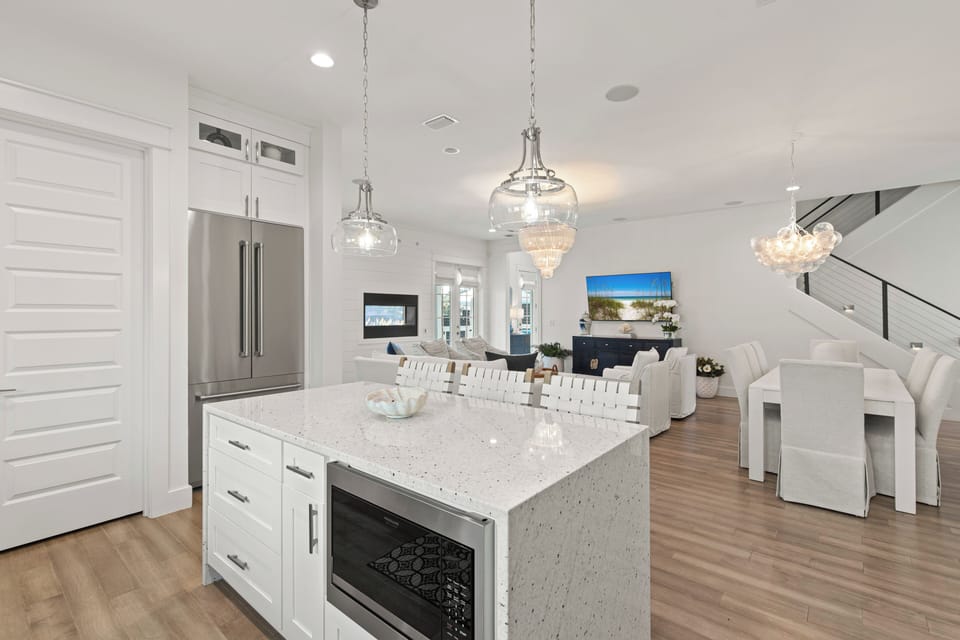 Gather around your stunning quartz island where sparkling pendant lights create perfect ambiance for memorable meals and conversations.