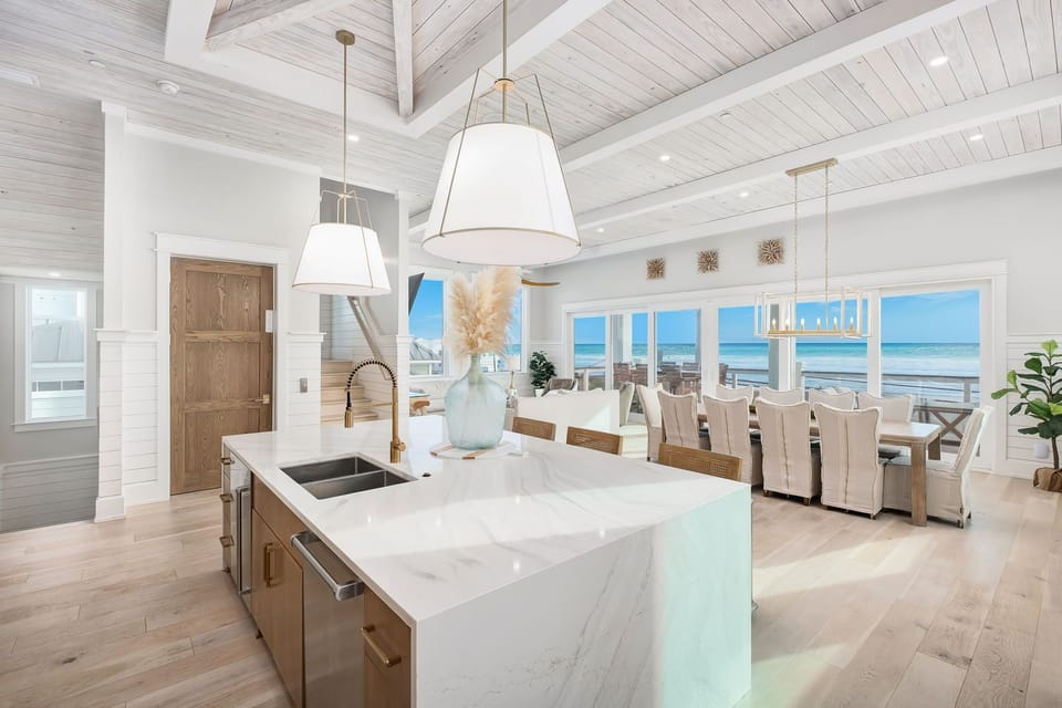 Your stunning oceanfront kitchen features marble countertops and soaring beamed ceilings, while panoramic sea views create the perfect backdrop for cooking and dining.
