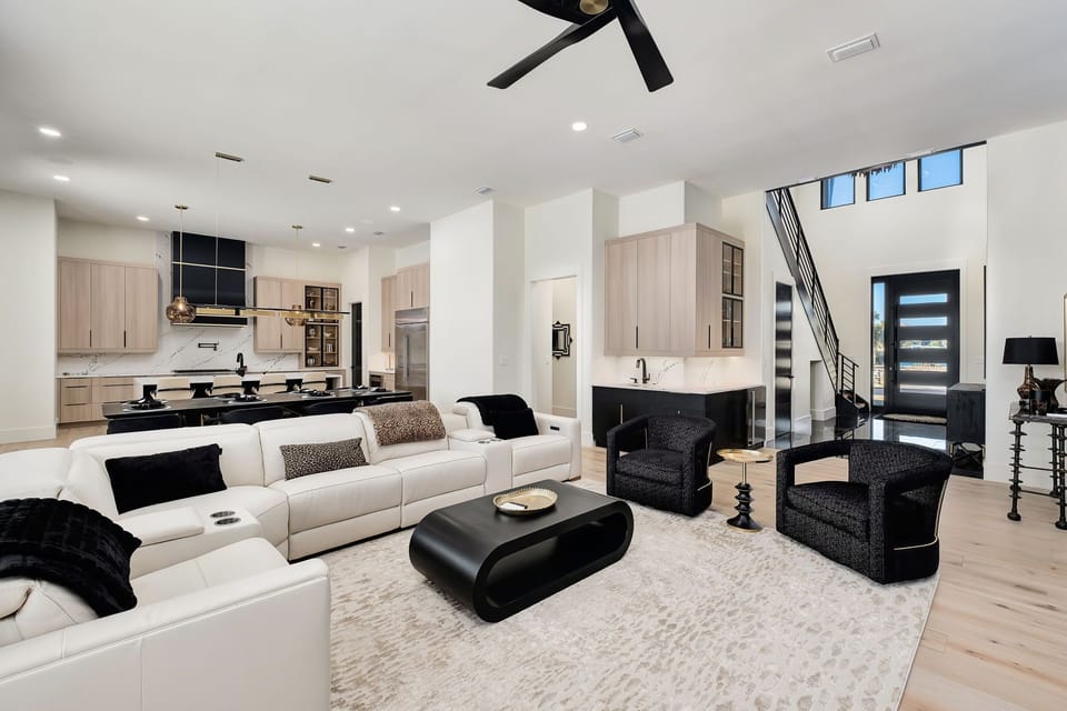 Step into your sophisticated open-concept retreat where sleek design meets comfort. Relax on plush white sofas while enjoying the modern kitchen's seamless flow.
