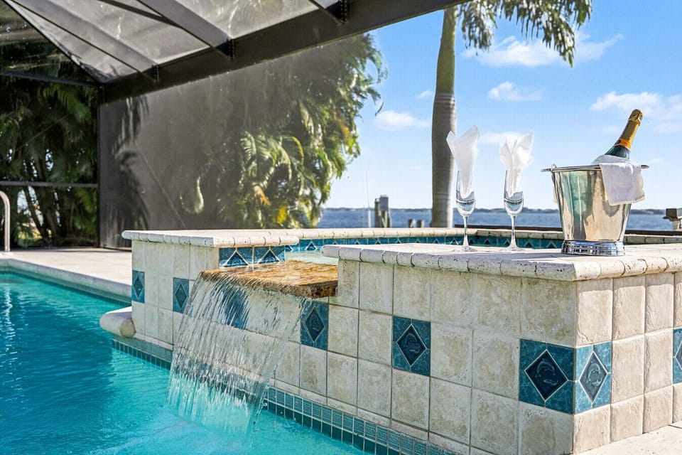 Poolside bubbles with a waterfall view of the river — vacation mode: activated. 🥂🌴