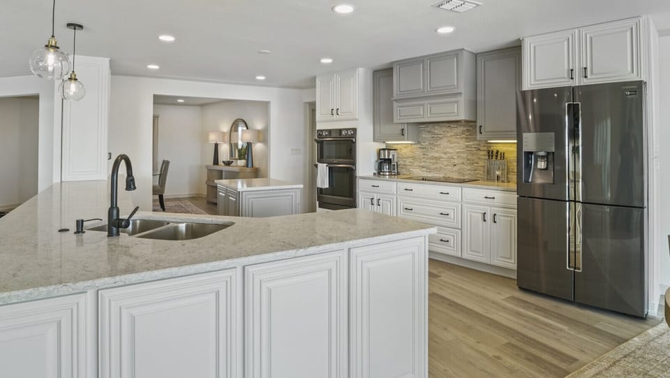 Gourmet kitchen with dual ovens, new stainless-steel Samsung appliances, and waterfront views