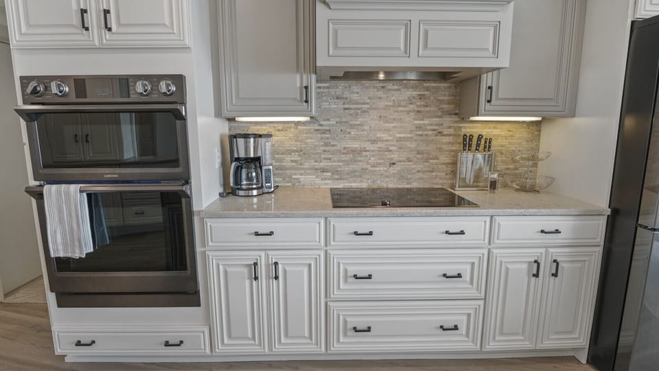 Gourmet kitchen with dual ovens, new stainless-steel Samsung appliances, and waterfront views