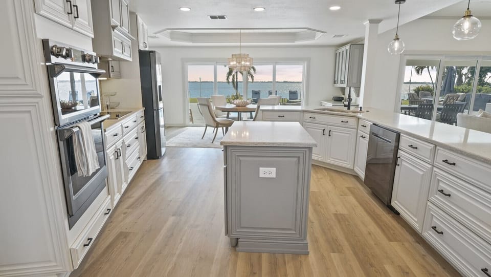 Gourmet kitchen with dual ovens, new stainless-steel Samsung appliances, and waterfront views
