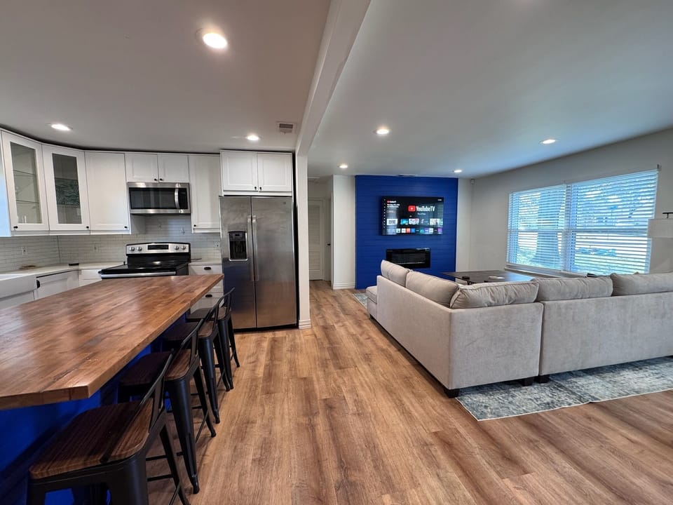 Spacious living space with a fully stocked kitchen, island seating & comfy sofa