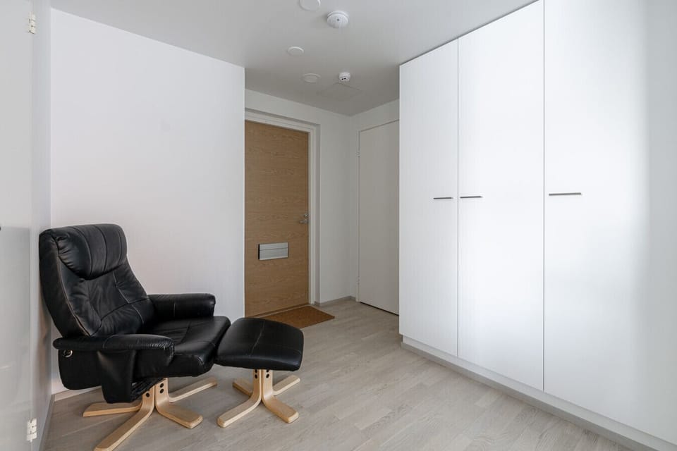 A functional and welcoming entryway featuring a comfortable leather recliner—the perfect spot to kick off your shoes and unwind the moment you arrive.