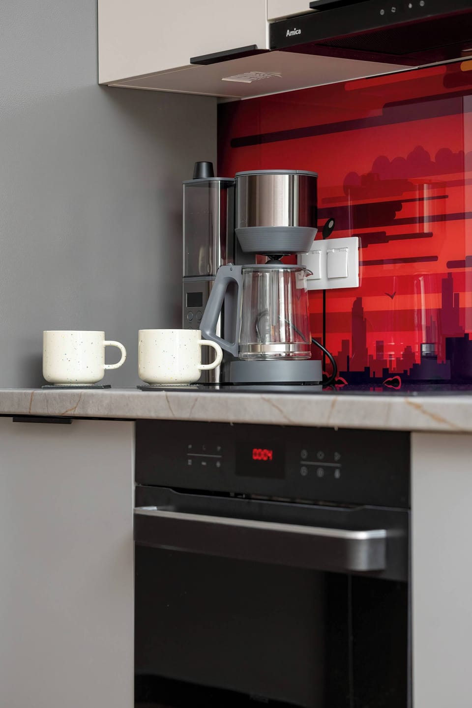 A dedicated coffee station on the counter features a drip machine and white ceramic mugs. This setup offers convenience for guests' morning routines.
