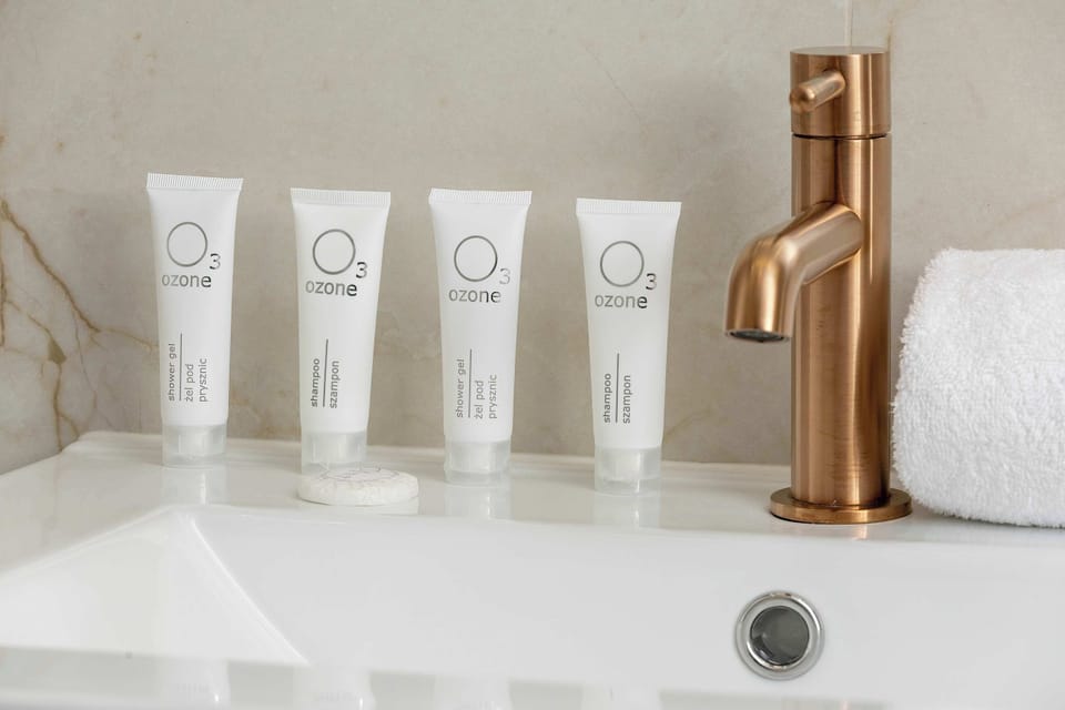 A detailed view reveals a luxury brushed gold faucet and a set of complimentary toiletries. These small details highlight the high standard of the stay.