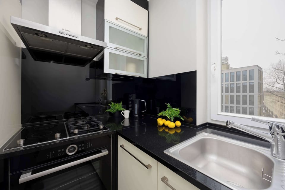 Modern kitchenette with white cabinetry, built-in appliances, and clean, functional design.