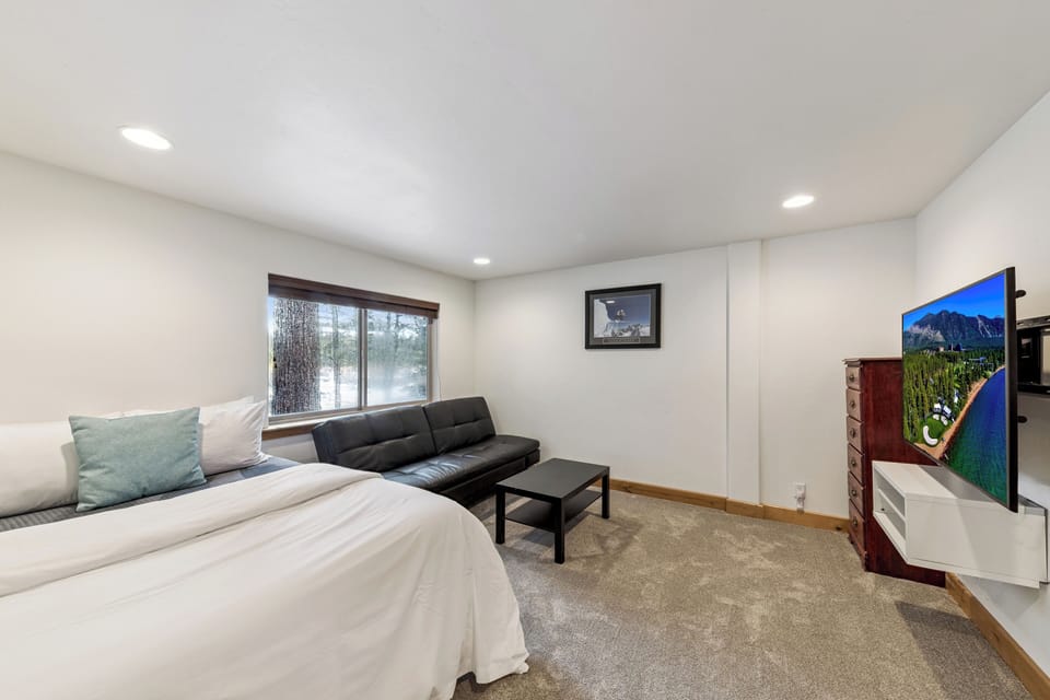 Unwind in your spacious retreat featuring a plush king bed, sleek sofa seating, and large-screen TV for cozy evenings in.