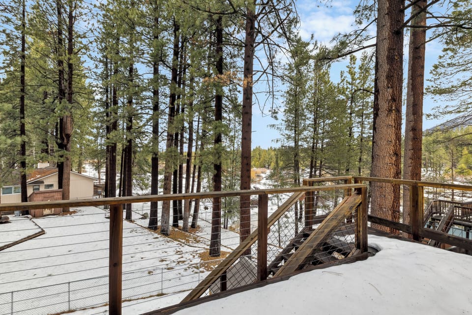 Step onto your private deck surrounded by towering pines and fresh mountain air, where winter's peaceful blanket creates the perfect alpine retreat.