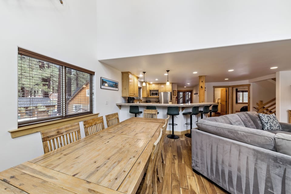 Gather around this spacious dining table where your group can share meals while enjoying forest views through large windows.
