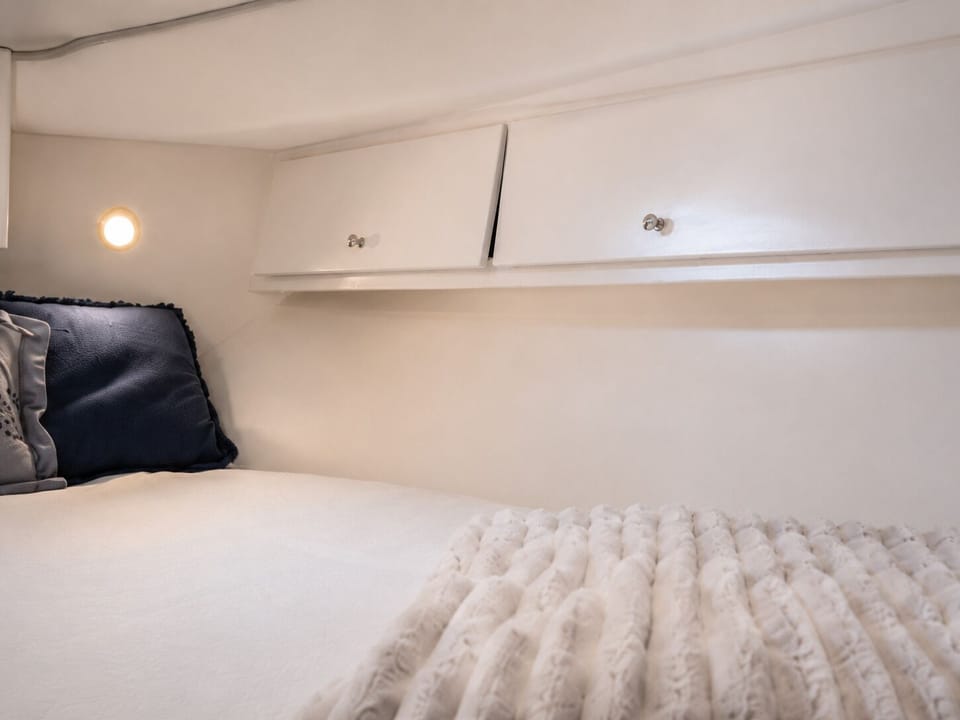Forward cabin double berth with storage and soft natural light
