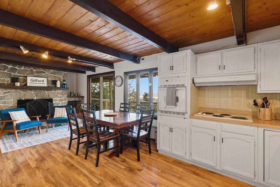 Fully equipped kitchen with white cabinetry, full-size appliances, and a dining table for six. Ideal for family breakfasts before skiing or relaxed dinners at home.