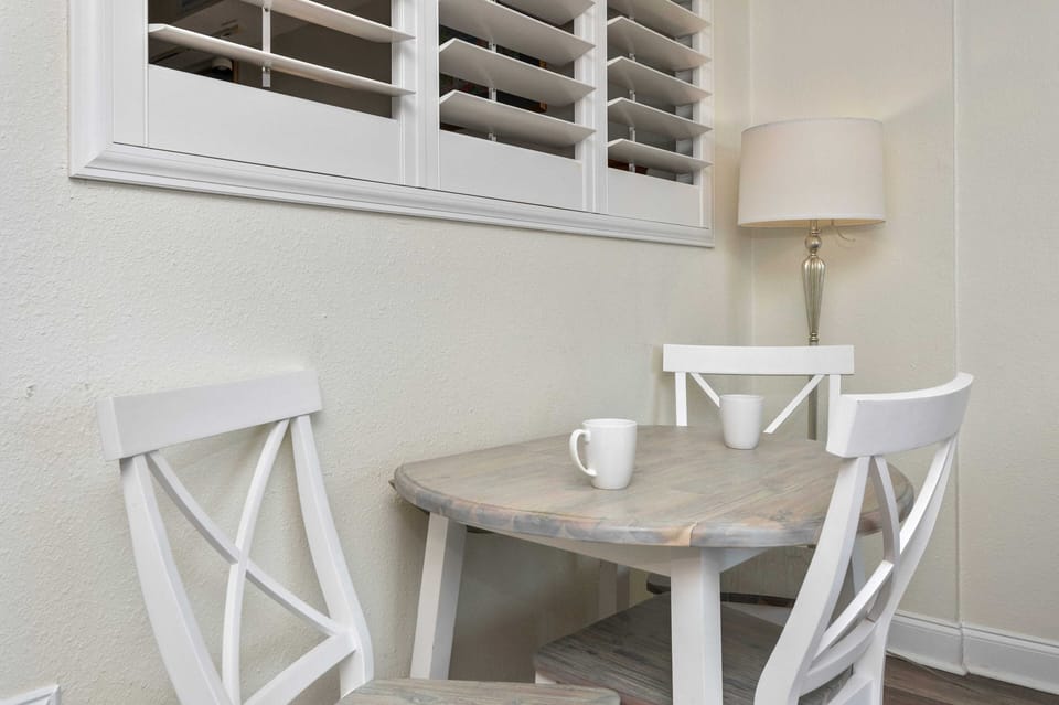 Cozy breakfast nook with bistro table, shutters, and soft lighting