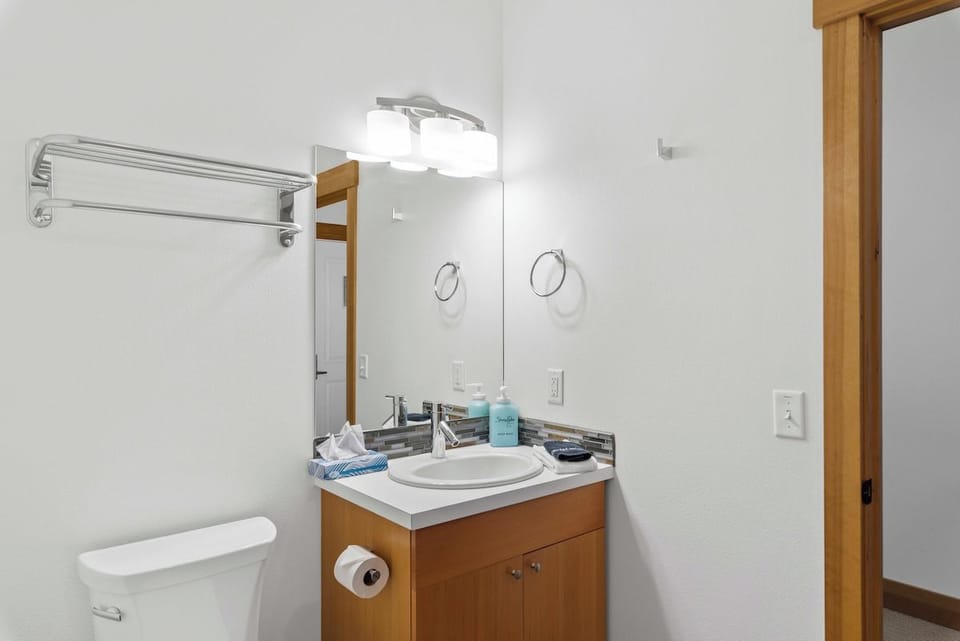 Your private bathroom features a modern vanity with fresh towels and complimentary toiletries, all set in a bright, spotless space.