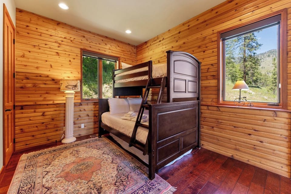 Rustic charm meets comfort in your cozy bunk room, where warm wood walls and a plush bunk bed await. Sink into soft linens and wake to mountain views through the windows, perfect for family memories.