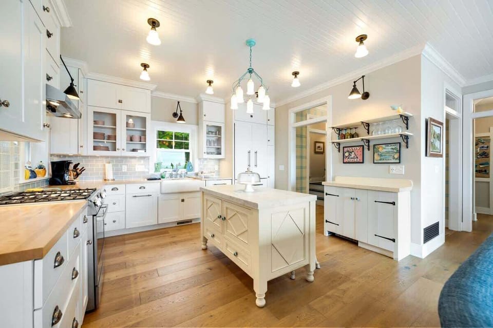 The fully equipped kitchen includes classic white cabinetry, butcher block counters, a drip coffee maker, and dishwasher—perfect for preparing meals together.