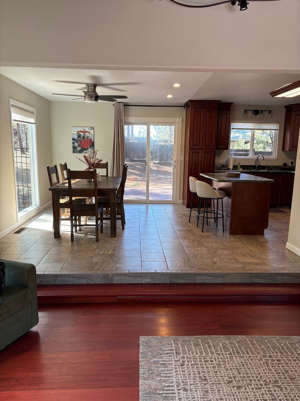 Bright kitchen and dining area with island seating and sliding door to backyard.