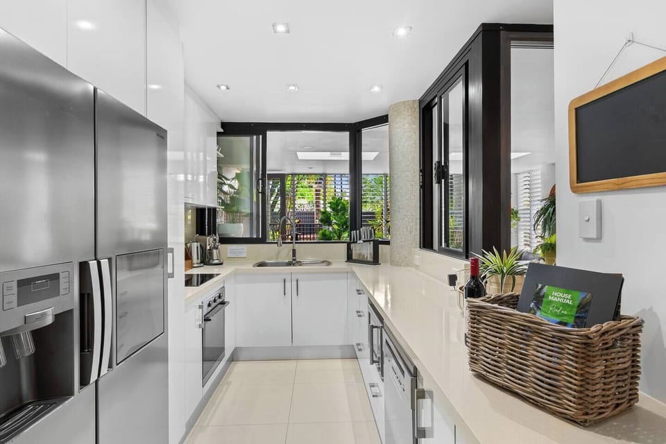 Cook with ease in the sleek, fully equipped kitchen featuring stone benchtops, quality appliances, a large fridge, dishwasher and plenty of storage. The open layout and servery window make preparing meals and entertaining simple and enjoyable daily.