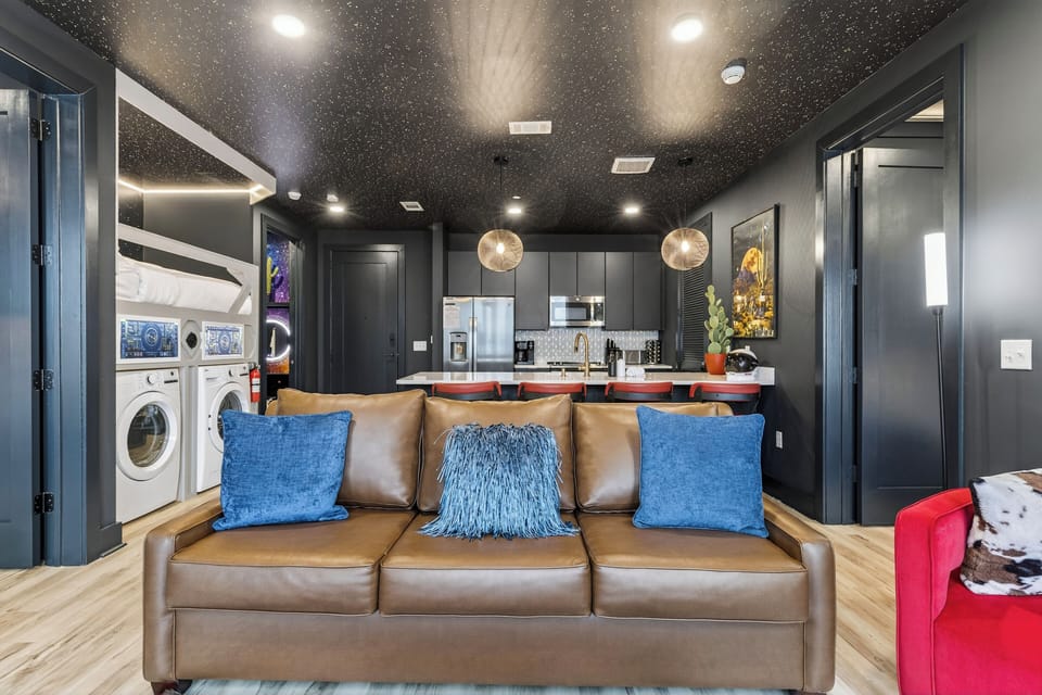 Moody, sun-filled lounge with statement seating, bold artwork, and oversized windows—an inviting spot to relax, chat, or recharge between city adventures.