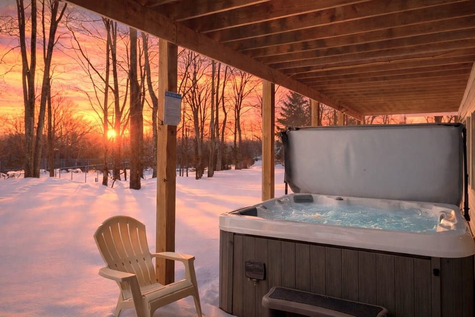 Private outdoor hot tub tucked under the deck, perfect for snowy evenings.