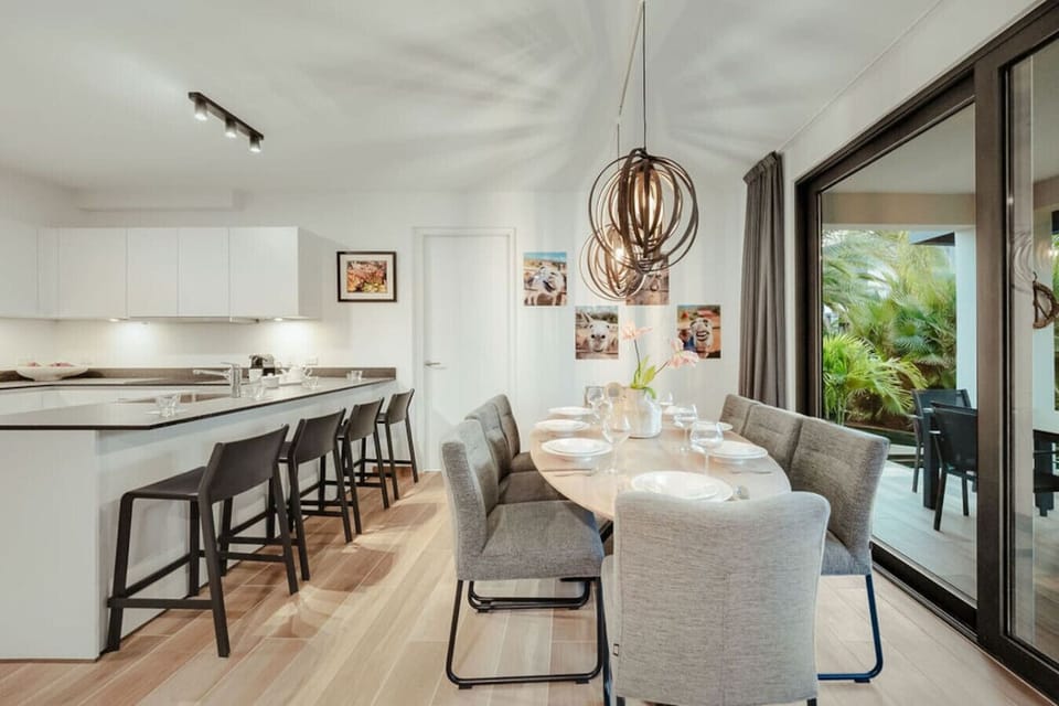 Host a memorable dinner under the glow of designer lighting with a perfect view of the lush greenery outside.
