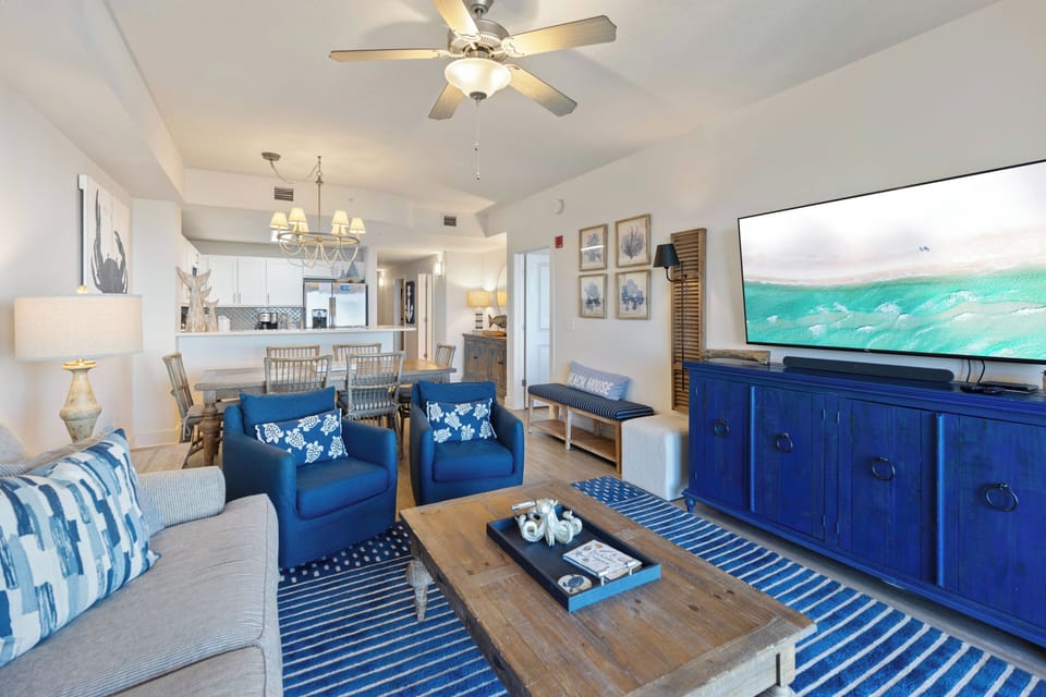 Relax in your coastal-themed living space with nautical blues, comfortable seating, and ocean views on the big screen.