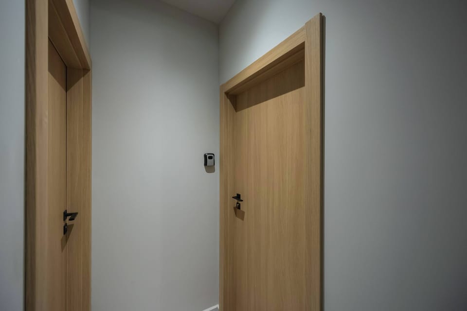 The hallway presents bright walls and light wood doors leading to the living areas.