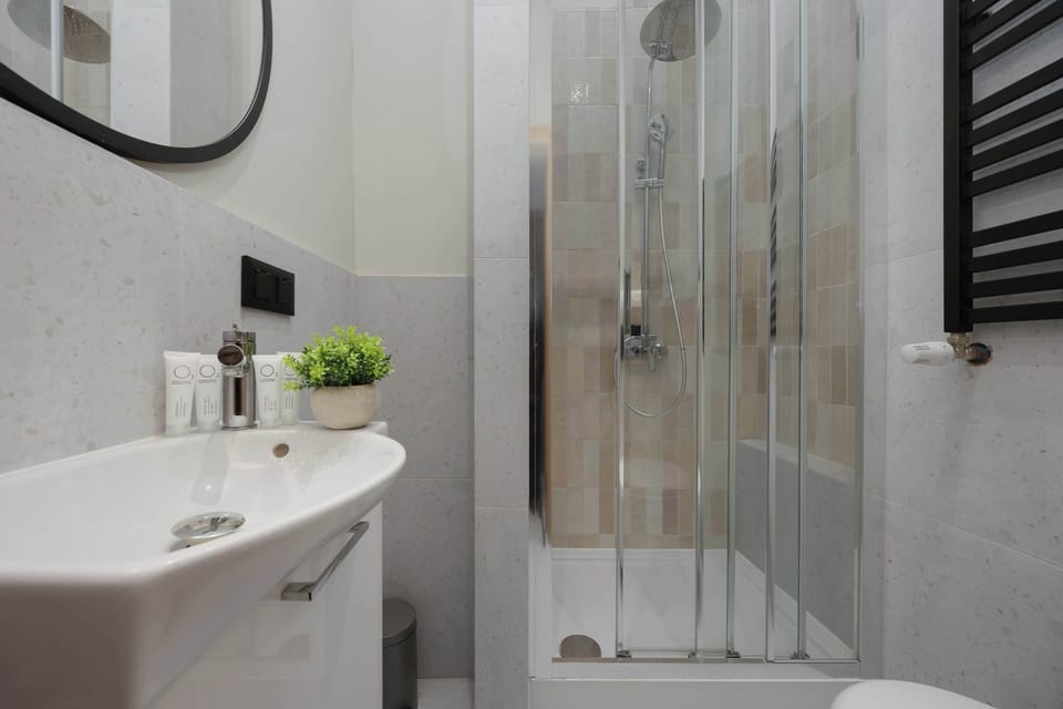 The bathroom features a clean shower with glass doors and a white vanity.