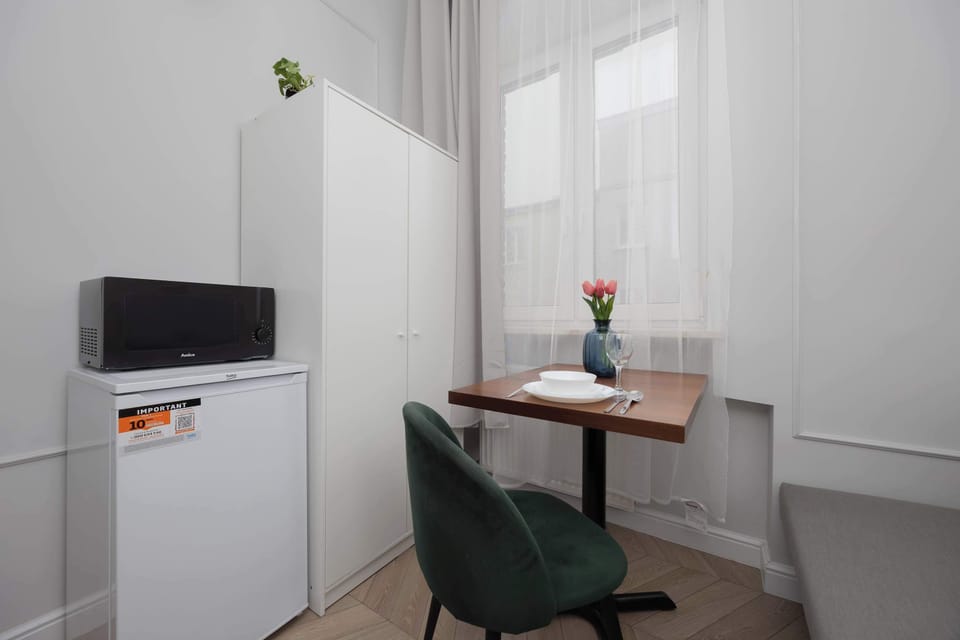 Storage space is provided by a tall white wardrobe located next to the dining area.