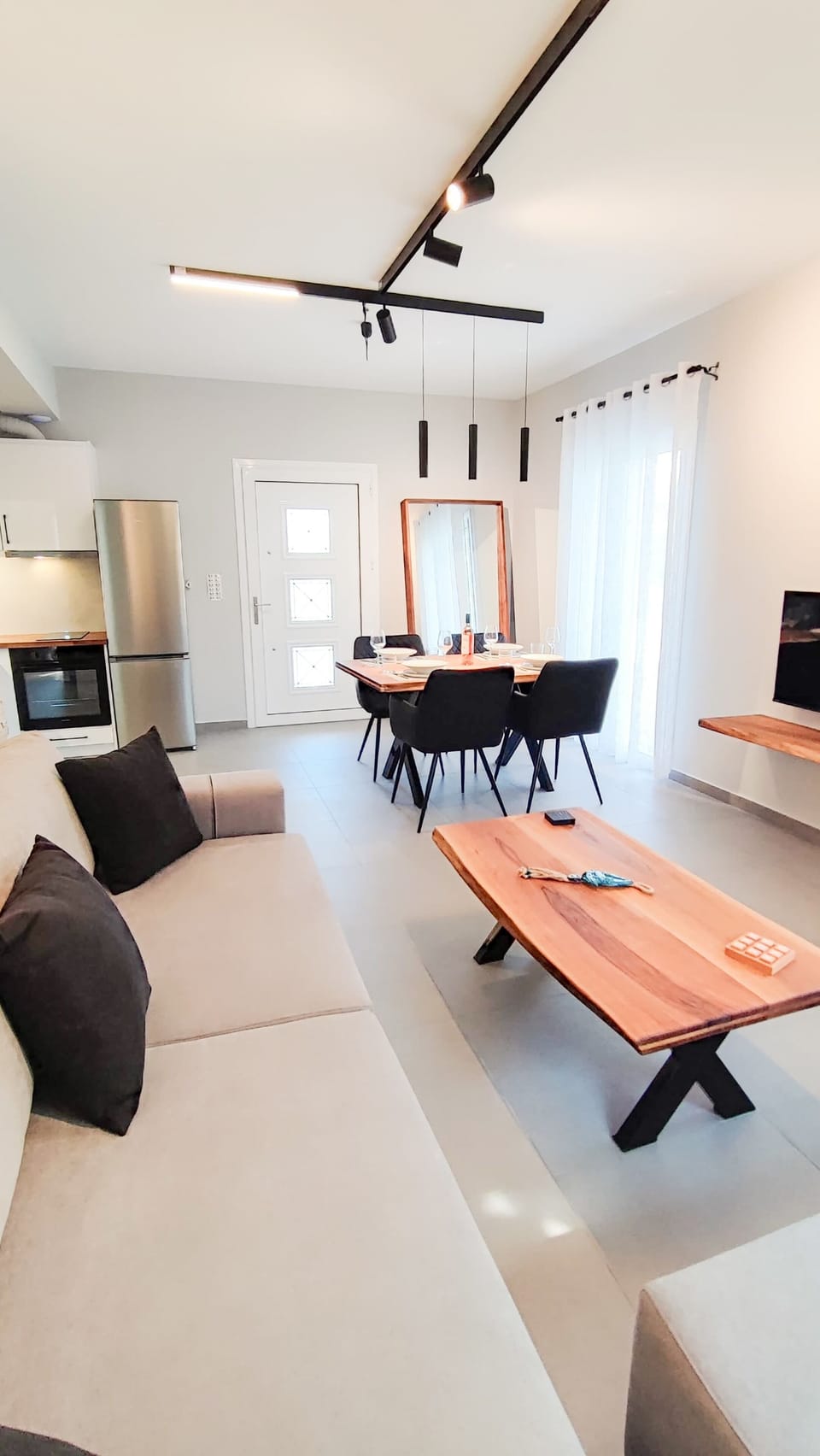 Contemporary open-plan lounge area with plenty of natural light and modern décor. Perfect for relaxing after visiting nearby beaches or exploring 