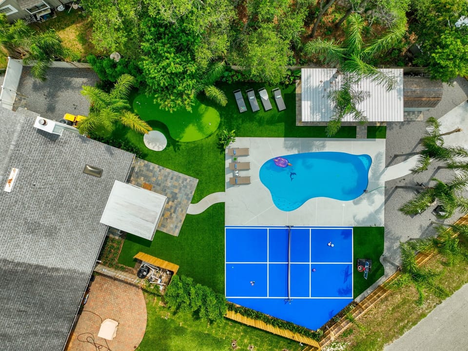 Bird's-eye view of your private backyard oasis - pool, pickleball court, putting green, fire pit and plenty of room to play