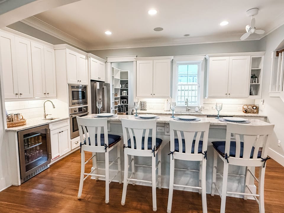 Whip up a feast in this bright, modern kitchen featuring crisp white cabinetry and premium stainless steel appliances. The spacious island with seating for four is the perfect spot for casual breakfasts or evening snacks.