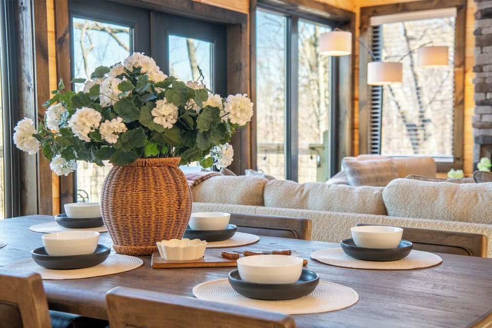 Gather around this beautiful dining table where fresh flowers and elegant place settings invite memorable meals together.