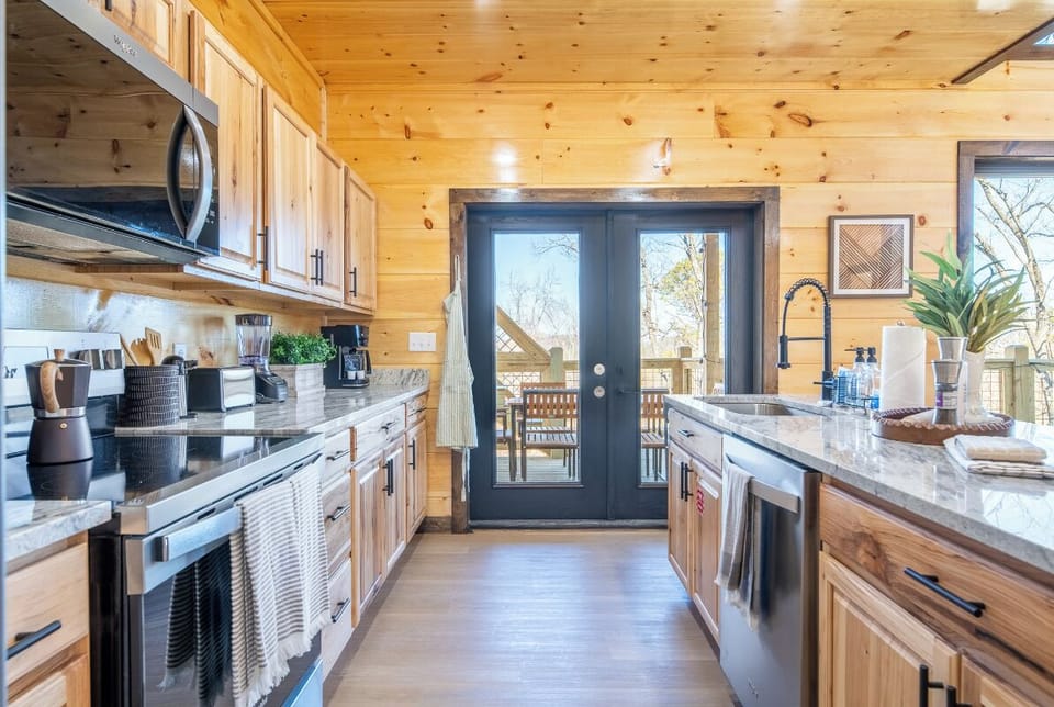 Your fully-equipped kitchen flows seamlessly to the outdoor deck, blending rustic wood charm with modern appliances for memorable meal prep.