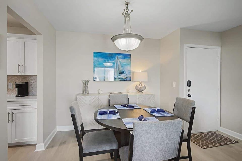 Gather around your elegant dining table for memorable meals beneath coastal artwork and soft pendant lighting.