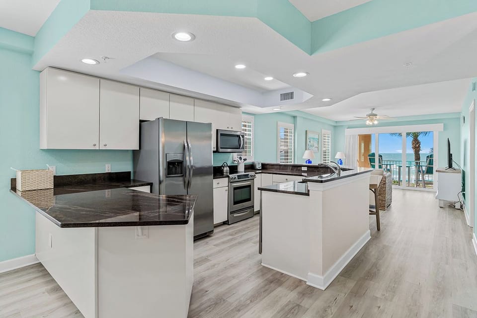 You'll love cooking in this bright, spacious kitchen with granite counters and ocean views from your balcony beyond.