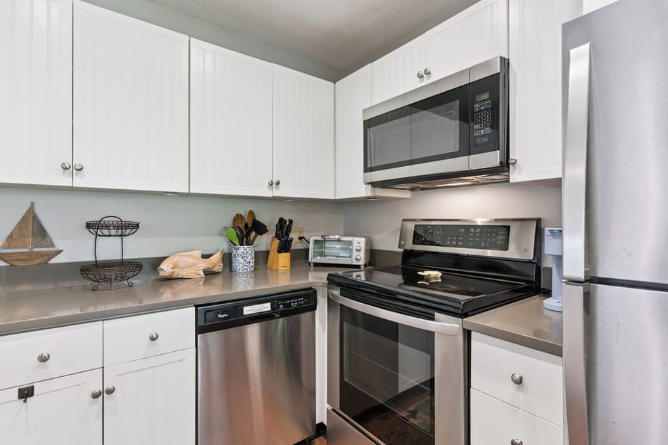 Step into your fully equipped kitchen with stainless steel appliances, crisp white cabinetry, and ample counter space—perfect for preparing meals and making yourself at home.