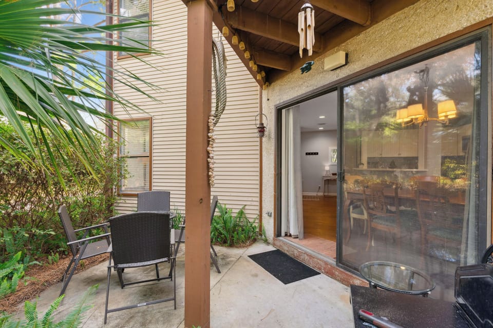 Step onto your private patio where tropical plants create a serene backdrop for morning coffee or evening relaxation.