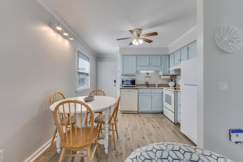 Your bright, coastal-style kitchen invites you to prepare meals together, with charming blue cabinets and a cozy dining nook bathed in natural light.