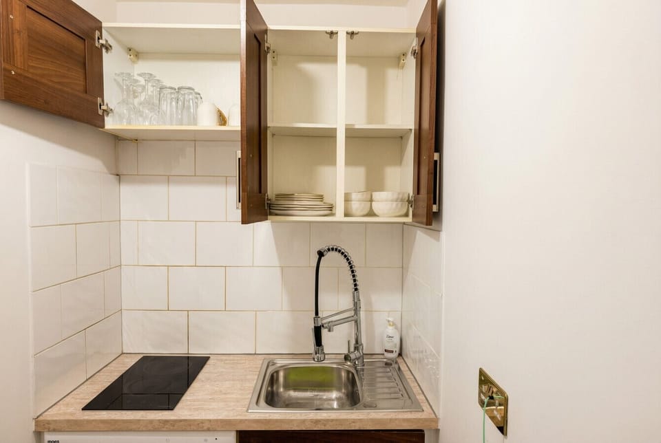 Compact kitchen stocked with glasses, plates and all the essentials.