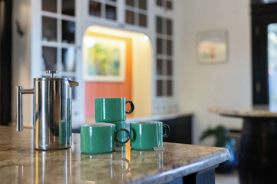 Start your mornings perfectly with fresh coffee from your sleek French press and charming green mugs, ready for those peaceful breakfast moments.