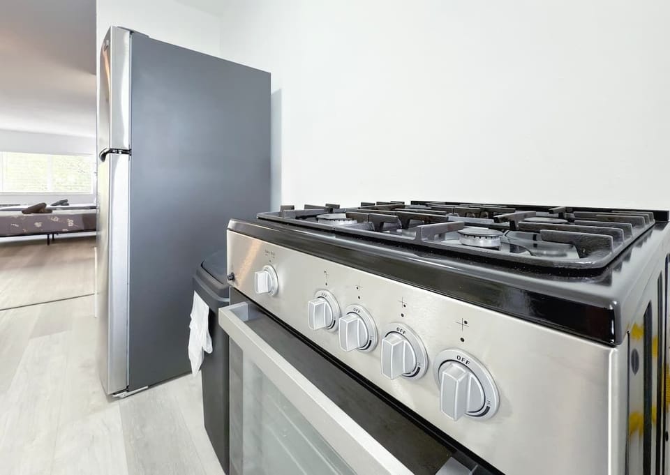 Fully equipped kitchen with fridge, stove, microwave, and essential cookware (no dishwasher).