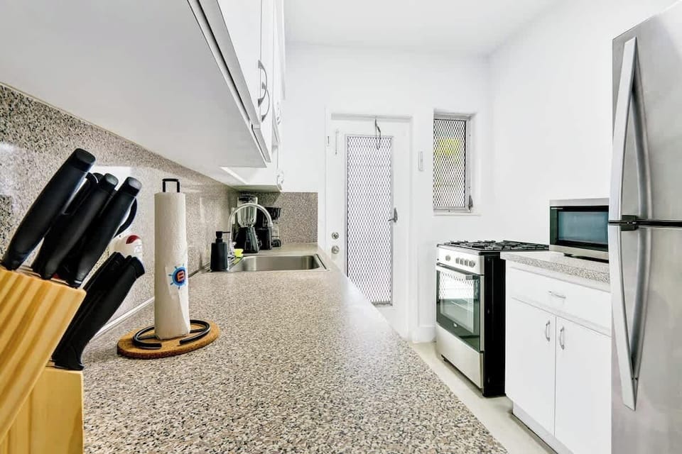 Fully equipped kitchen with fridge, stove, microwave, and cookware, ready for home-style meals.